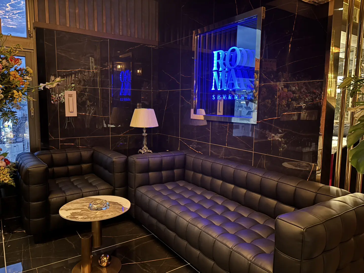 ROMA SEVEN ラウンジ席／黒大理石壁とブルーネオンサイン、黒革タフテッドソファ